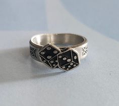 This ring was designed with the casino dice symbol. The beautiful pewter ring is a silver color and the background is blackened to bring out the fine detail of the design. Our rings are 100% Lead and nickel free pewter and made in the USA The top design part of the ring measures approx. 12.5mm x 8.5mm  The ring band tapers from about 5mm to about 4mm at the bottom and is about 1.5mm thick Picture shows size compared to a US Dime Rings are available in sizes 4 to 7 (half sizes also) Casino Jewelry, Pewter Ring, Ladies Ring, Top Design, Ring Band, Rings Statement, Women Rings, Band Rings, Silver Color