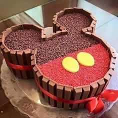 a mickey mouse cake with chocolate decorations on it's face and ears in the shape of hearts