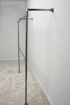 an empty room with a metal handrail in the corner and carpet on the floor