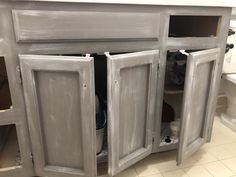 an unfinished kitchen cabinet with the doors open