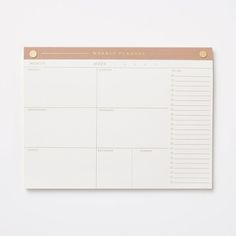 a white and gold weekly planner on top of a table