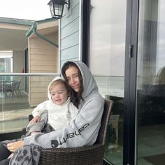 a woman sitting on top of a chair next to a child