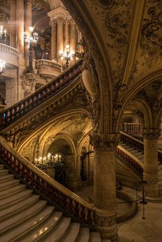 an ornate staircase with chandeliers in a large building