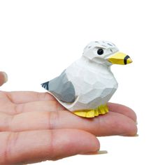 a small bird sitting on top of someone's hand in front of a white background