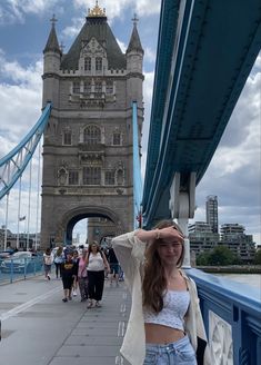 a woman standing on the side of a bridge