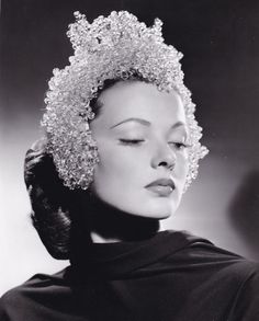 a black and white photo of a woman wearing a tiara with her eyes closed