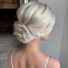 the back of a woman's head with blonde hair styled into a low bun