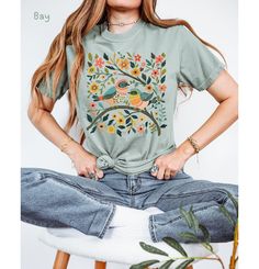 Elevate your wardrobe with this whimsical birds and flowers t-shirt, featuring a stunning nature-inspired graphic. This colorful botanical art print adds a cute and vibrant touch to any outfit. *🌿 High-quality graphic t-shirt with a whimsical bird and floral design *🐦 Made from soft, comfortable fabric perfect for everyday wear *🌸 Available in multiple sizes and colors to suit your style *👕 Durable print that stands up to washing and regular use *🎁 Great gift idea for bird lovers, nature en Nature-inspired Relaxed Fit Tops For Spring, Casual Bird Print Tops For Summer, Nature-inspired Tops With Plant Print For Summer, Casual Summer Tops With Bird Print, Summer Nature-inspired Tops With Plant Print, Summer Cotton Tops With Bird Print, Spring Nature-inspired Tops With Graphic Print, Nature-inspired Relaxed Fit Short Sleeve Tops, Nature-inspired Crew Neck T-shirt For Summer