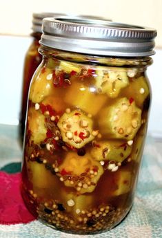 a jar filled with pickles sitting on top of a blue and white table cloth