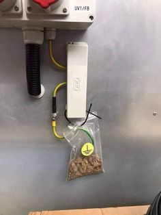 an electronic device mounted to the side of a metal wall next to a bag of food