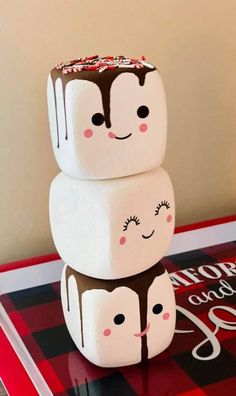 three marshmallows stacked on top of each other with faces drawn on them