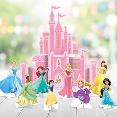 there are many princess figurines in front of a pink castle on the table