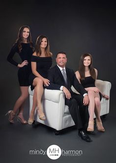 a group of people sitting on top of a white chair in front of a black background