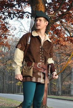 a man dressed in costume standing next to a tree