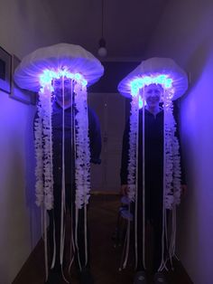 two people are standing in front of some jellyfishs with blue lights on them