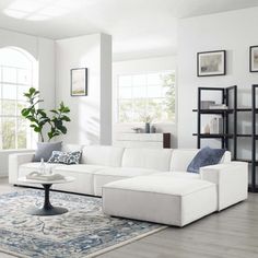 a living room filled with white furniture and lots of windows