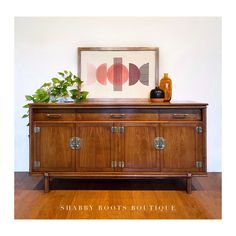 a wooden cabinet with two vases on top of it