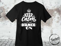 a black t - shirt with the words keep calm and dance on it