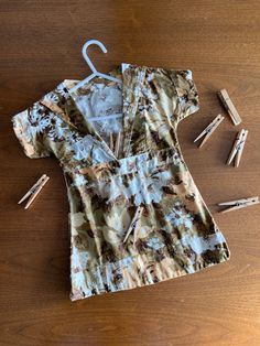 an umbrella and clothes pins on a wooden table next to a shirt that has been worn