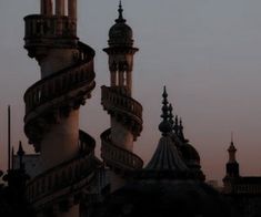 an airplane flying in the sky over a building with spiral staircases and spires