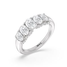 a three stone diamond ring with four stones on the band and side stones in white gold