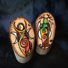 two painted wooden shoes sitting on top of a black surface