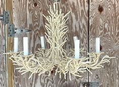 a white chandelier hanging from a wooden wall