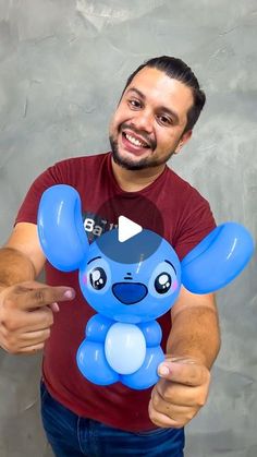 a man pointing at an inflatable blue toy