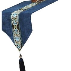 a blue table runner with tassels and an ornate design on the edge is shown