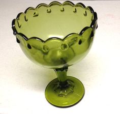 a green glass bowl sitting on top of a table