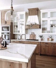 a large kitchen with wooden cabinets and marble counter tops, along with an island in the middle