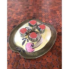 a plate with some food on it sitting on a tile floor next to penny coins