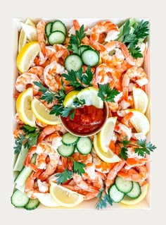 shrimp, cucumbers and lemon slices on a platter with ketchup