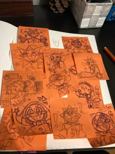 several pieces of orange paper with drawings on them