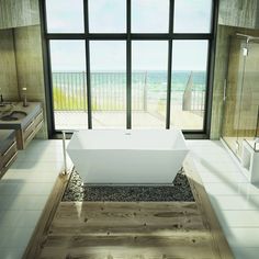 a bathroom with a large window overlooking the beach and ocean is shown in this image