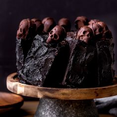 a cake with chocolate frosting and skulls on top is sitting on a wooden platter