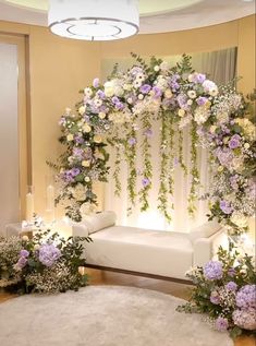 a white couch sitting under a flower covered arch