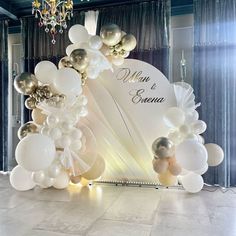 a white and gold wedding arch decorated with balloons