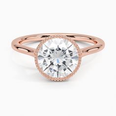 a rose gold ring with a round cut diamond in the center