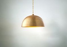 a light that is hanging from a chain on a wall in a room with white walls