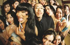 a group of people posing for the camera with one woman brushing her teeth in front of them