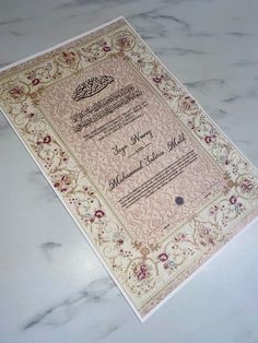 an ornate wedding card on a marble table