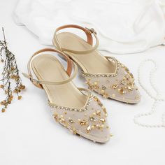 a pair of shoes sitting on top of a table next to a beaded necklace