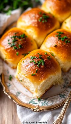 small rolls on a plate with green sprinkles next to some silverware