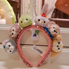 a group of stuffed animals sitting on top of a pink headband