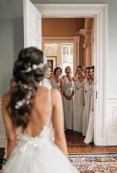 the bride is getting ready to walk down the aisle in her wedding dress, and she's looking at herself in the mirror