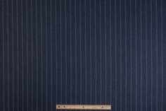 a ruler sitting on top of a piece of blue paper with pinstripe pattern