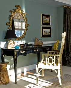 a room with a desk, chair and mirror on the wall in front of it