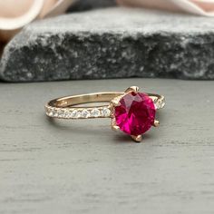 This beautiful ring is made from genuine 925 sterling silver with rose gold plating. Ring details- -The Main stone is a round cut 6.5mm lab created Pink Ruby -Side stones are 1mm and 2mm simulated diamonds -Ring is casted in solid 925 sterling silver with rose gold plating (rhodium and yellow gold plated also available, please check the drop down menu for more options) -The Total face height of the ring measures 7mms and the band width measures 2mms -Each ring is handmade, so please allow suffic Rose Gold Ring With Lab-created Ruby, Rose Gold Rings With Lab-created Ruby, Pink Gold Round Ruby Ring With Prong Setting, Pink Gold Ruby Ring With Prong Setting, 14k Rose Gold Ruby Ring With Prong Setting, Rose Gold Round Cut Ruby Promise Ring, Rose Gold Ruby Ring With Round Cut Center Stone, Rose Gold Ruby Ring With Center Stone, Rose Gold Ruby Ring With Brilliant Cut For Promise