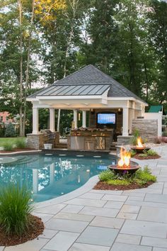 a backyard with a pool, fire pit and gazebo